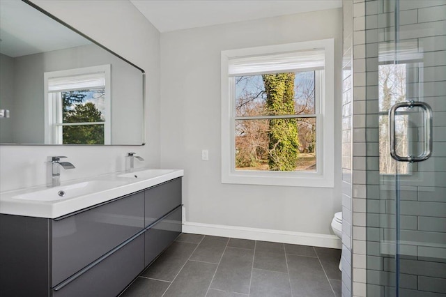 bathroom with tile patterned floors, a shower with door, vanity, and toilet