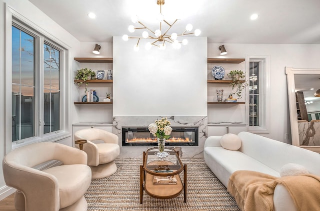 living room featuring wood-type flooring, a fireplace, and a chandelier