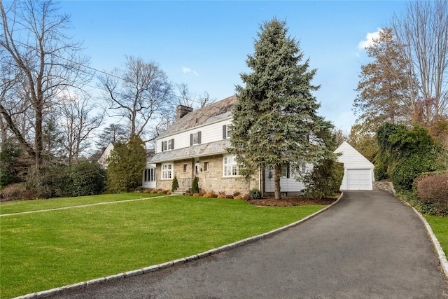 view of front of home featuring a front lawn, an outdoor structure, and a garage