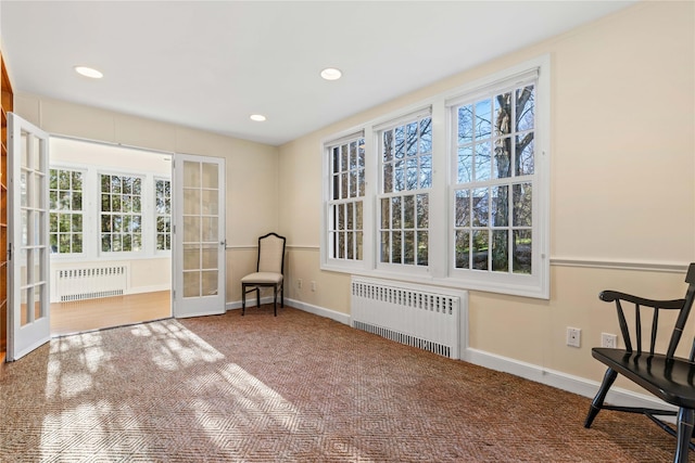 unfurnished room featuring carpet, radiator, and french doors