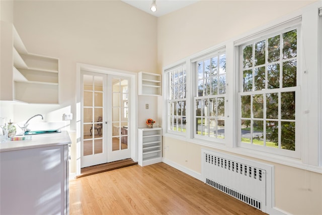 interior space with radiator heating unit, french doors, and sink