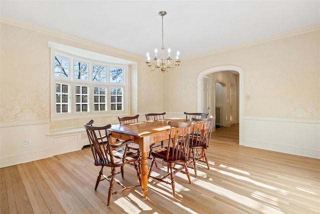 dining area featuring a chandelier, light wood-type flooring, and ornamental molding