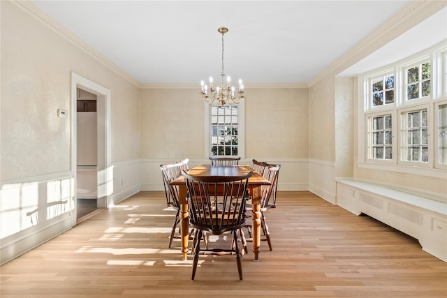 dining room featuring crown molding, radiator heating unit, light hardwood / wood-style floors, and a notable chandelier