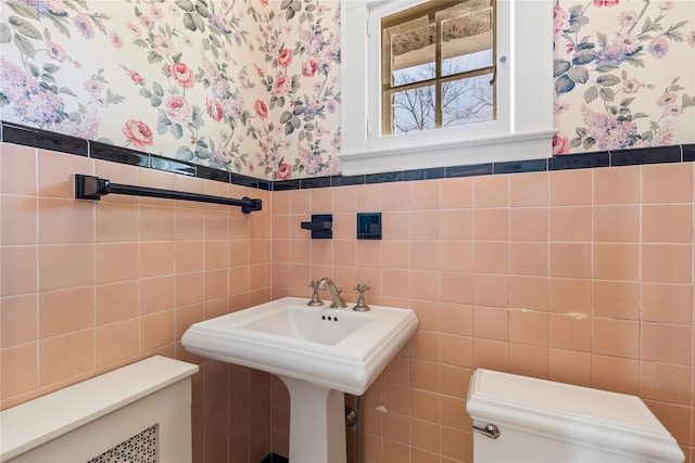 bathroom featuring tile walls and toilet