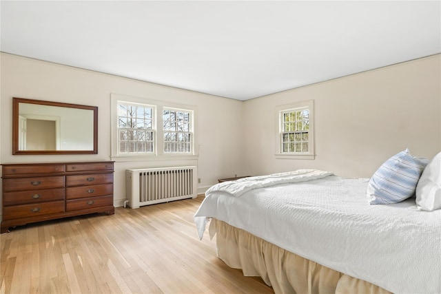 bedroom featuring light wood-type flooring and radiator