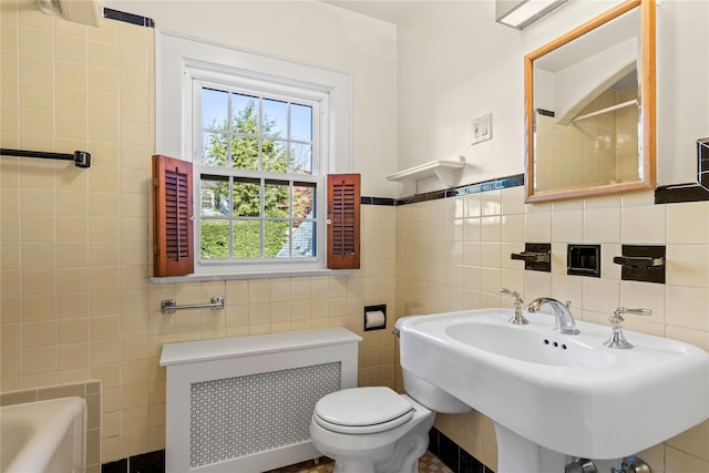 full bathroom with sink, radiator heating unit, toilet, independent shower and bath, and tile walls