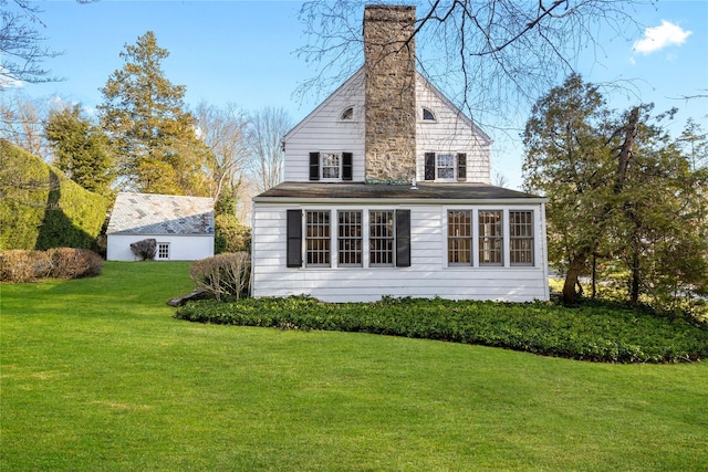 rear view of property featuring a lawn