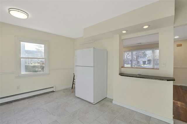 kitchen with white fridge and a baseboard radiator