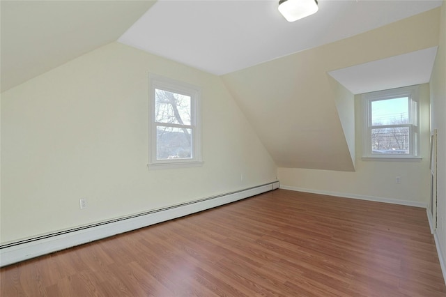 additional living space with hardwood / wood-style floors, a baseboard radiator, and lofted ceiling