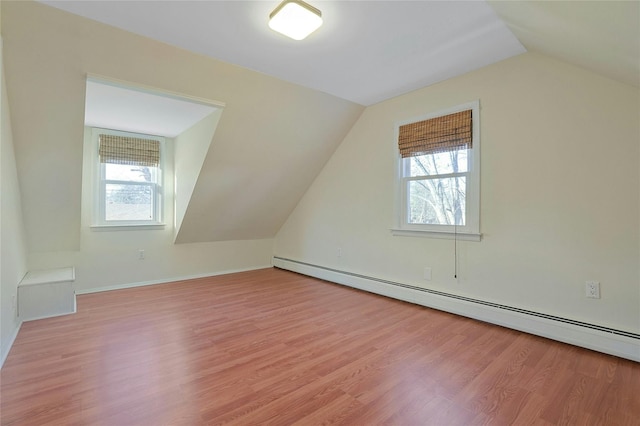 bonus room featuring light hardwood / wood-style flooring, a baseboard radiator, and vaulted ceiling