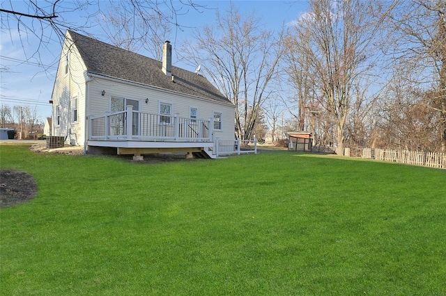 back of house featuring a lawn and a deck