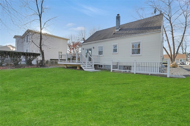 rear view of house with a lawn and a deck