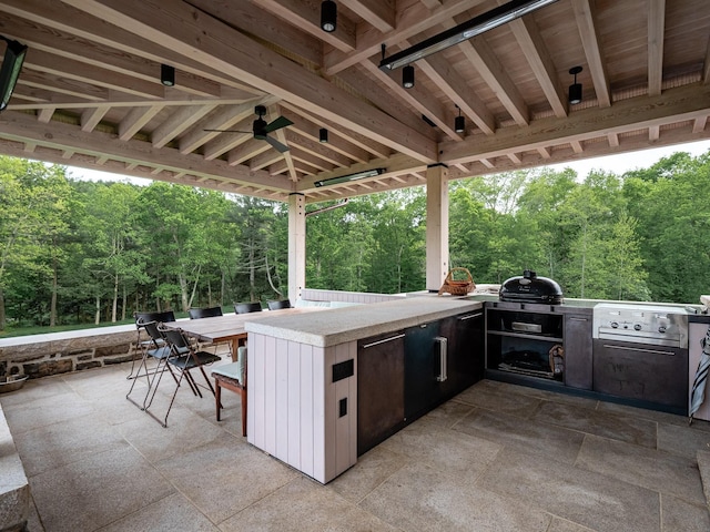 view of patio featuring ceiling fan, exterior kitchen, a grill, exterior bar, and a gazebo