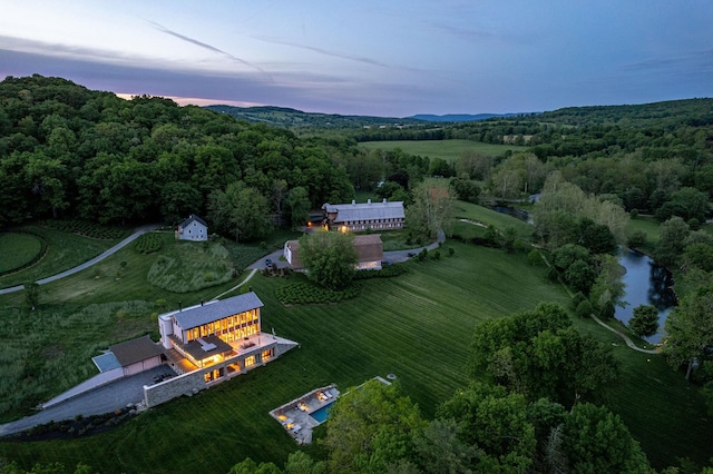 aerial view at dusk featuring a water view and a rural view