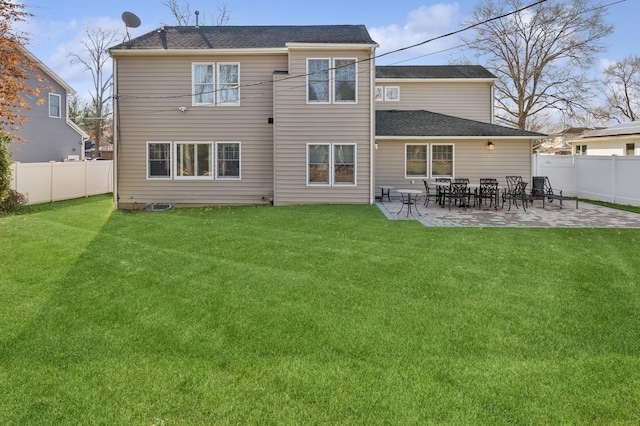 rear view of house with a lawn and a patio