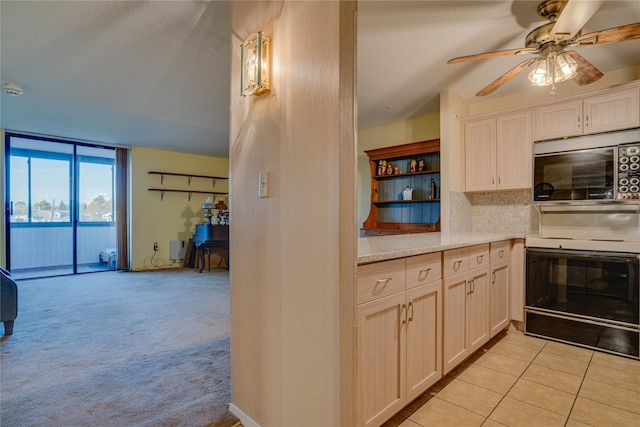 kitchen featuring electric stove, tasteful backsplash, light colored carpet, and ceiling fan