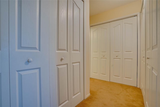 hallway featuring light colored carpet