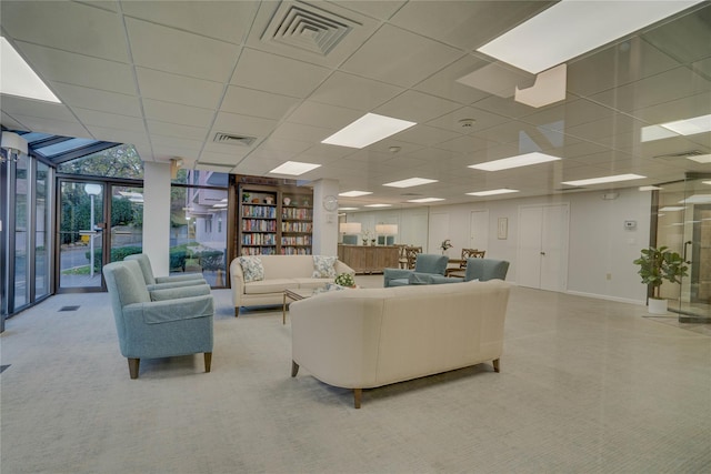 living room featuring a paneled ceiling and floor to ceiling windows