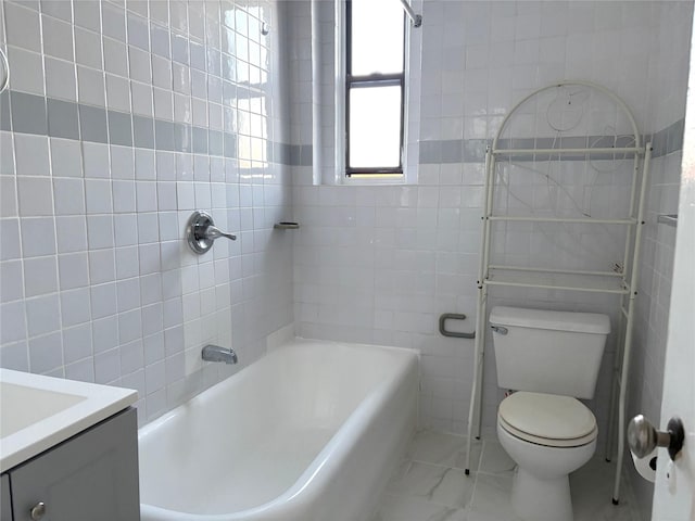 bathroom with vanity, toilet, and tile walls