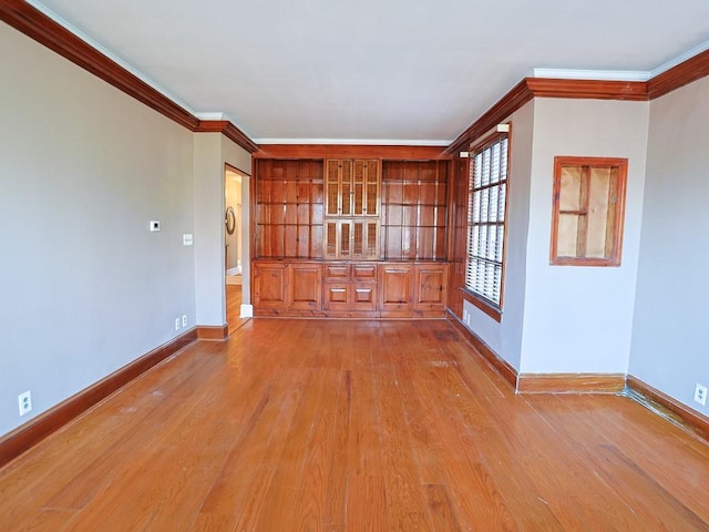 empty room featuring crown molding and light hardwood / wood-style flooring