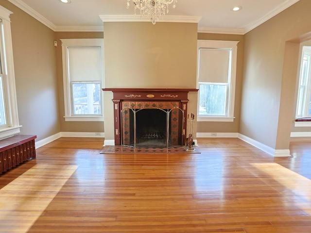 unfurnished living room with a wealth of natural light, light hardwood / wood-style floors, and ornamental molding