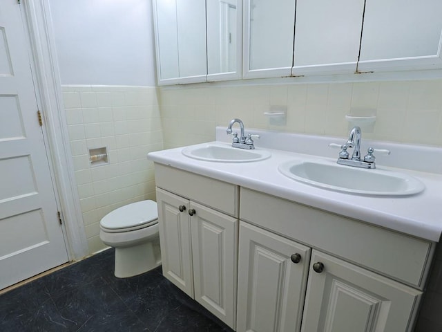 bathroom with tile patterned flooring, vanity, toilet, and tile walls