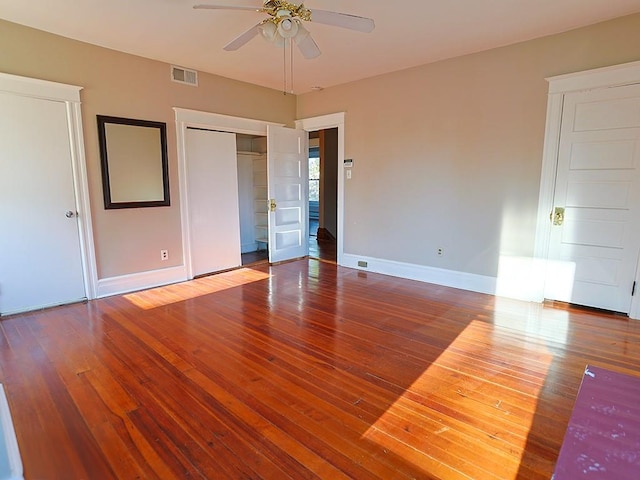 unfurnished bedroom featuring ceiling fan, a closet, and hardwood / wood-style flooring