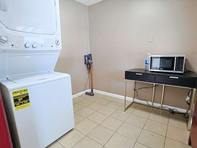 laundry room with light tile patterned floors and stacked washer / dryer