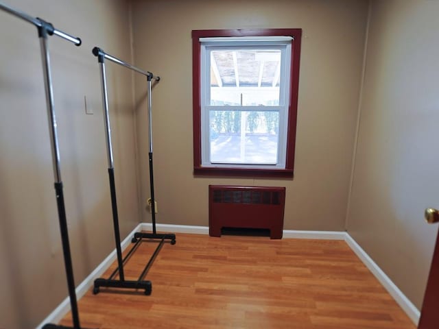 doorway to outside with light wood-type flooring and radiator heating unit