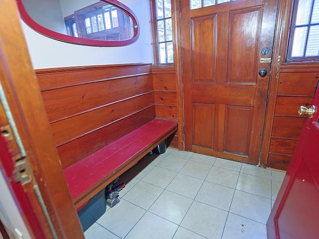 entryway featuring wood walls and light tile patterned floors