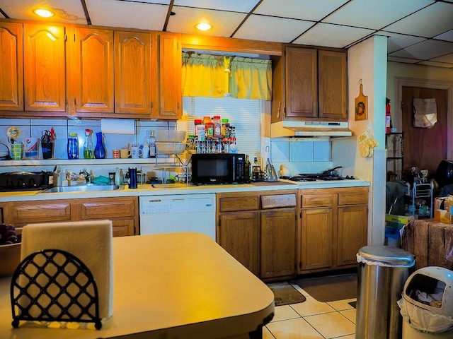 kitchen featuring backsplash, light tile patterned flooring, white appliances, and sink