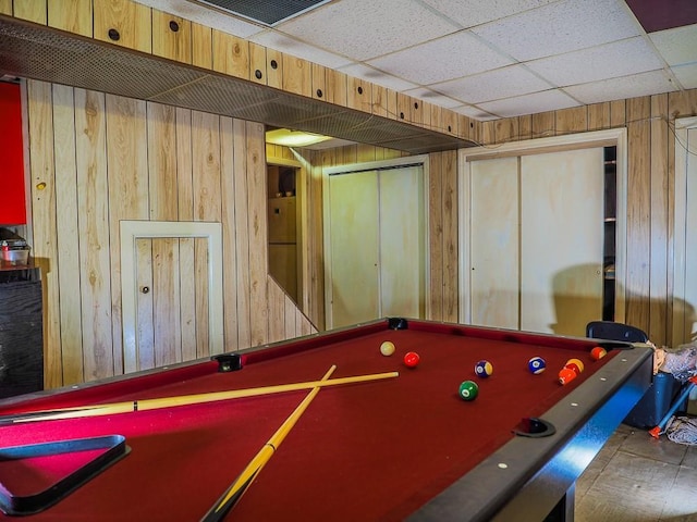 recreation room featuring a drop ceiling, wood walls, and billiards