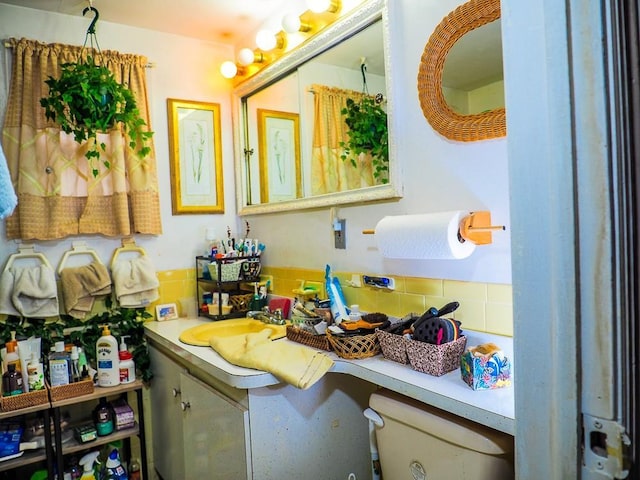 bathroom with vanity, toilet, and tasteful backsplash