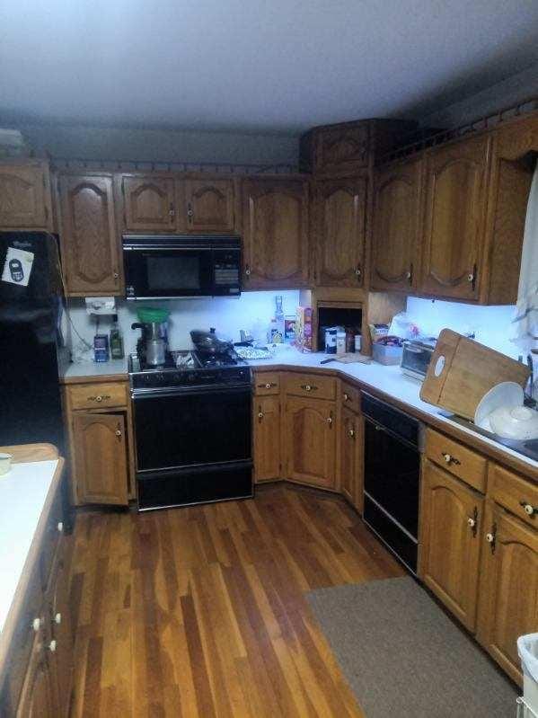 kitchen featuring dark wood-type flooring and black appliances