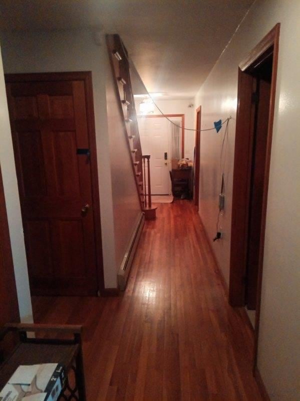 hallway with dark hardwood / wood-style flooring and a baseboard heating unit