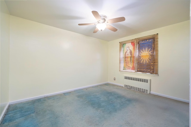 carpeted spare room with radiator and ceiling fan