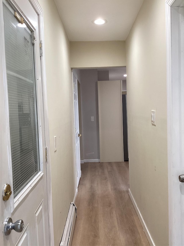 hallway with wood-type flooring and a baseboard radiator