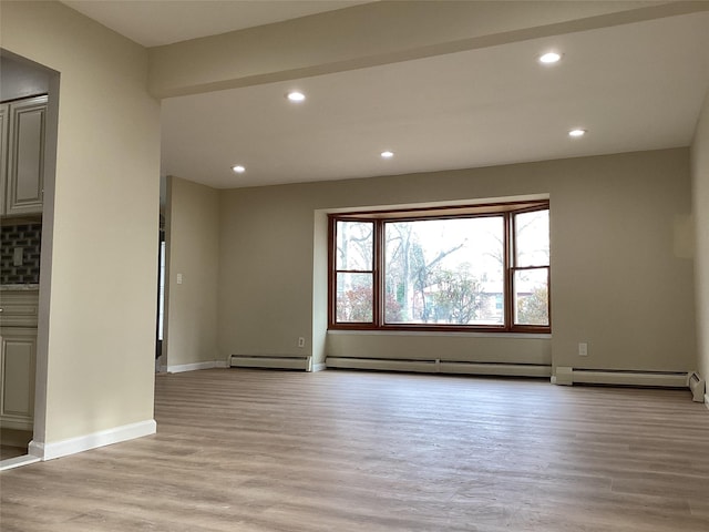 unfurnished living room with a baseboard radiator and light wood-type flooring