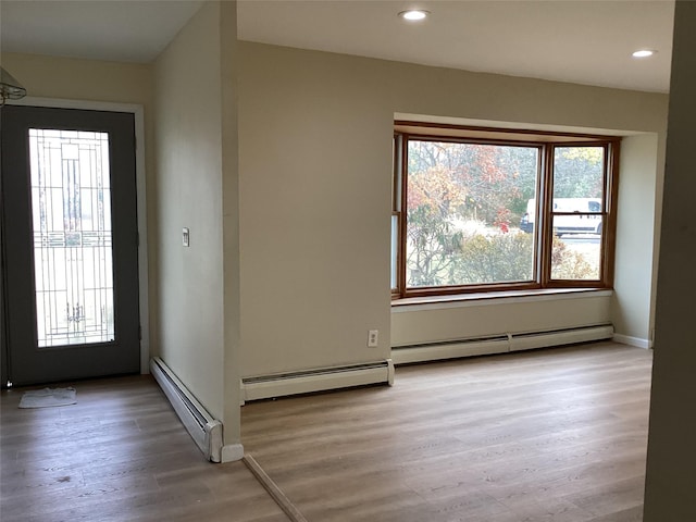 foyer with light wood-type flooring and baseboard heating