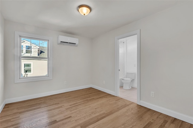 spare room with light hardwood / wood-style floors and a wall unit AC