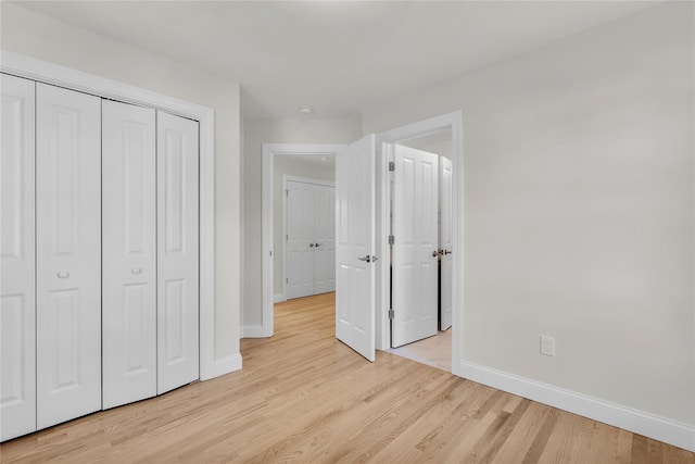 unfurnished bedroom with a closet and light hardwood / wood-style flooring