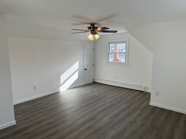 additional living space with vaulted ceiling, ceiling fan, dark hardwood / wood-style floors, and a baseboard heating unit