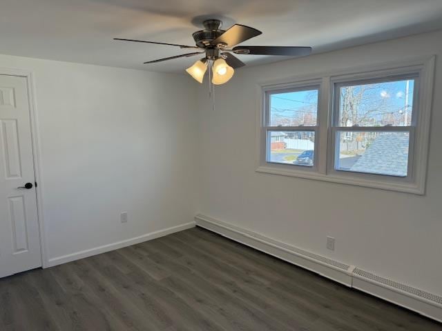 empty room with ceiling fan, dark hardwood / wood-style flooring, and a baseboard heating unit