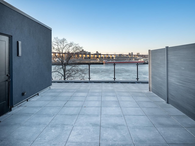 view of patio with a balcony and a water view