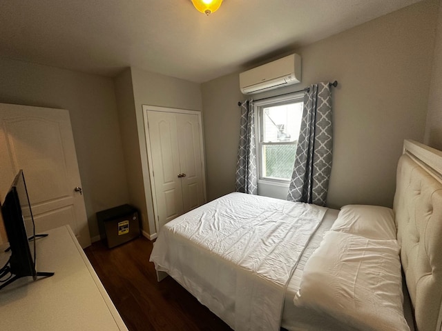 bedroom featuring a wall mounted air conditioner, dark hardwood / wood-style floors, and a closet