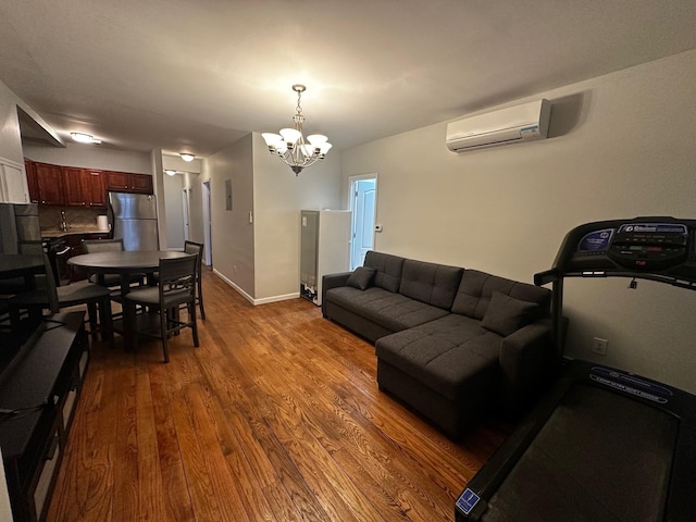 living room featuring a wall mounted AC, dark wood-type flooring, and a notable chandelier