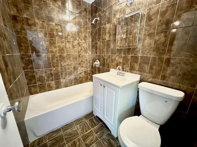 full bathroom featuring toilet, vanity, tile walls, and tiled shower / bath