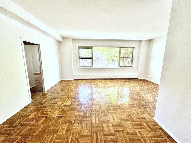 empty room with a baseboard radiator and light parquet floors