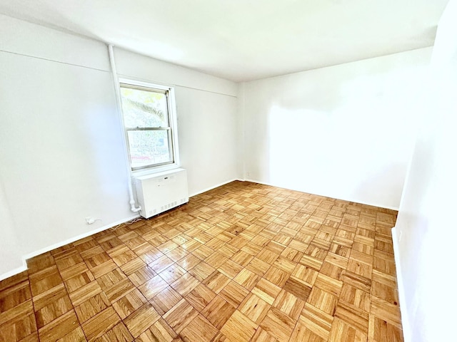 spare room with light parquet flooring and radiator