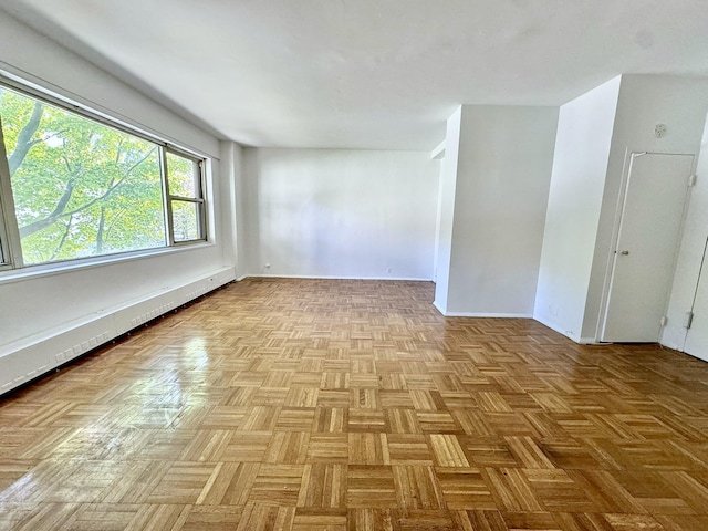 empty room featuring baseboard heating and light parquet floors